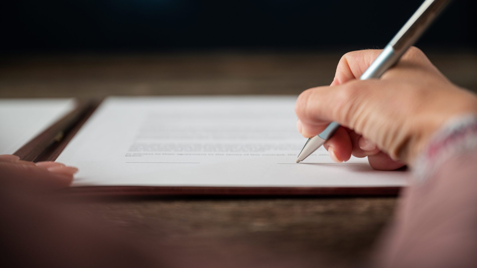 Female signing a document during a High-Asset Divorce case in Franklin, TN